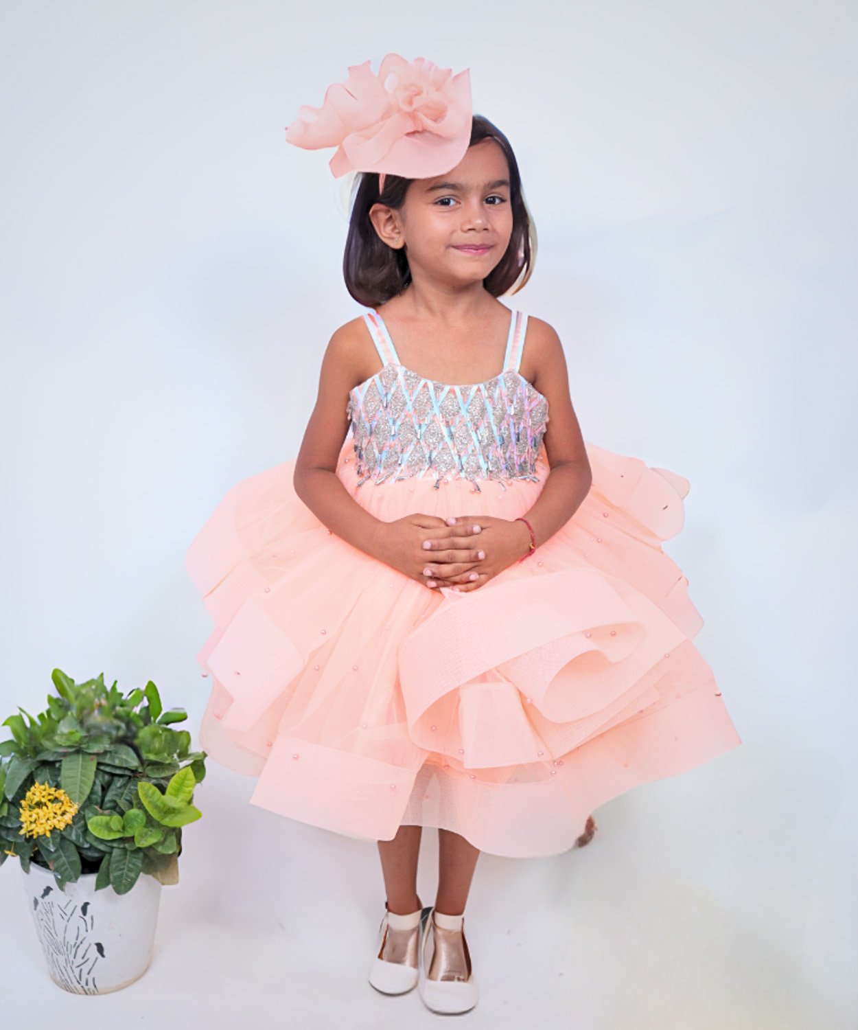 Peach Frock With Sequined Bodice, Layered Skirt, And Matching Ruffled Headpiece.